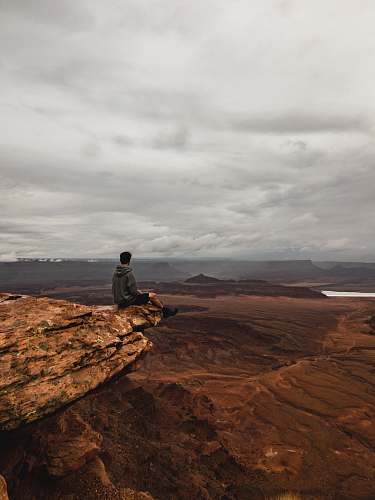 moab man sitting on cliff hiking
